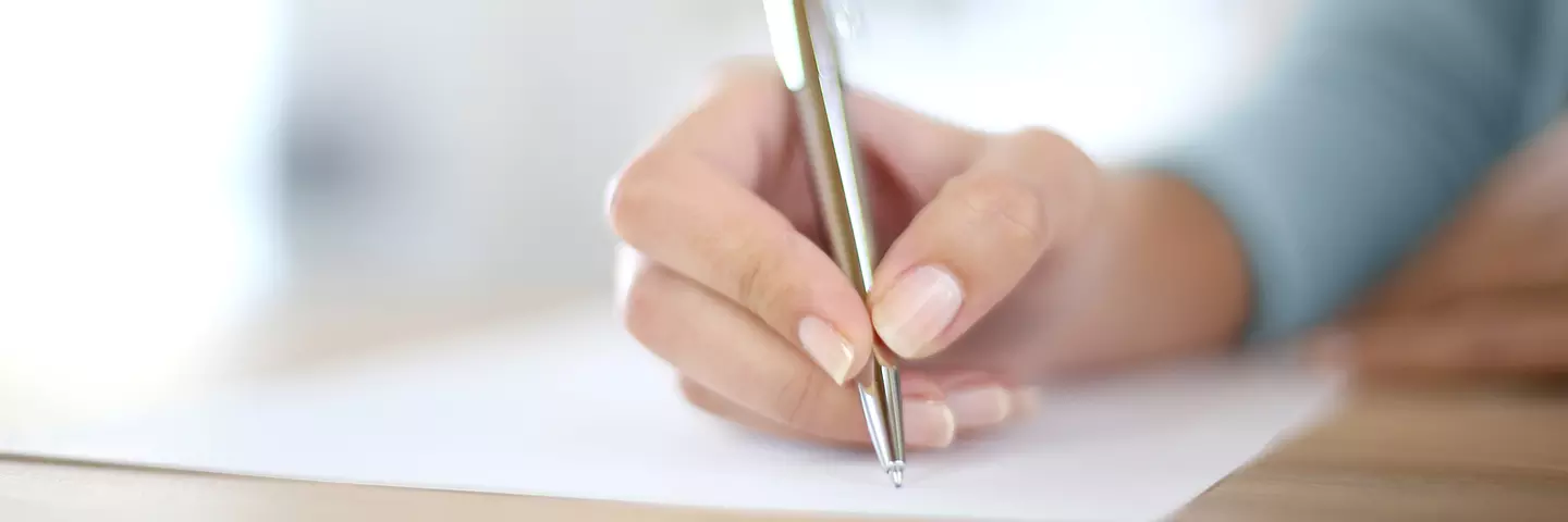 Hand schreibt auf Papier