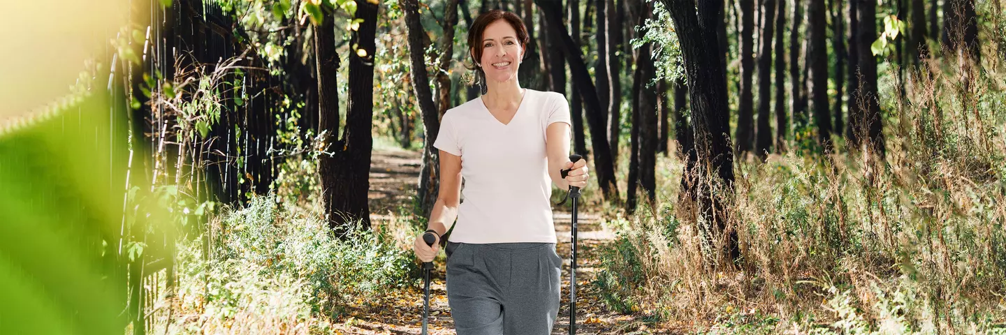 Frau mit Nordic Walking Stöcken im Wald
