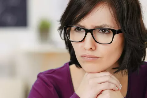 Frau mit Brille nachdenklich