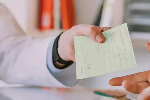 Arzt mit einem grünem Rezept in der Hand
