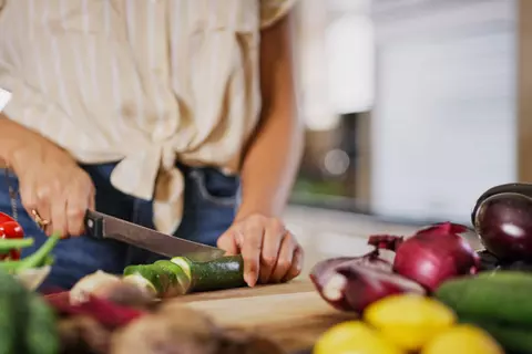 Frau schneidet frisches Gemüse