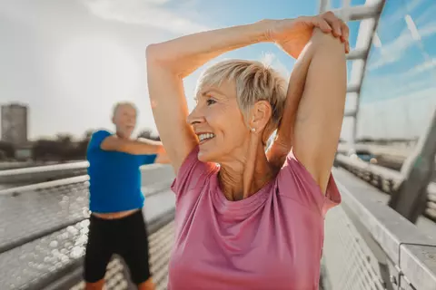 Älteres Paar macht Dehnübungen draußen in der Sonne