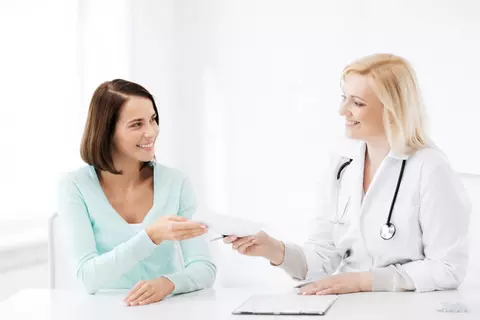 Ärztin übergibt Patientin ein Dokument