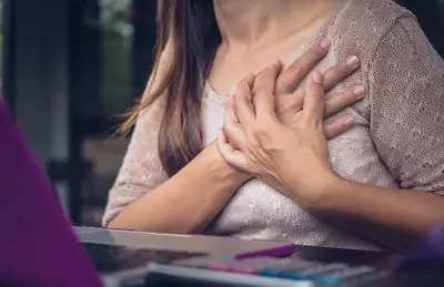 Frau hält sich die Hände auf dem Herz